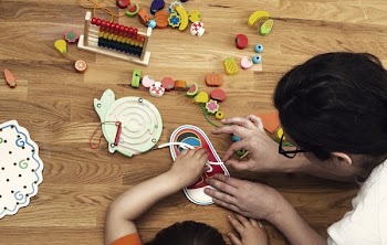 Early Childhood Educator With Toys And Child