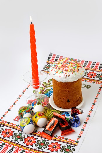 Easter cake eggs and a candle on a table cloth still life