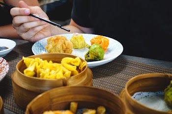 Eating Chinese steamed and fried dim sum with chopsticks 