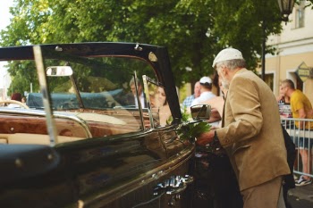 Eesti Tartu Laulupidu walk in July 2019 with black vintage cabriolet car in midsummer.