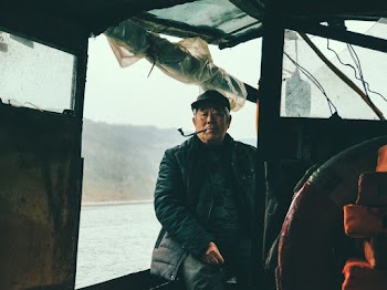 Elderly Man Sitting on Boat