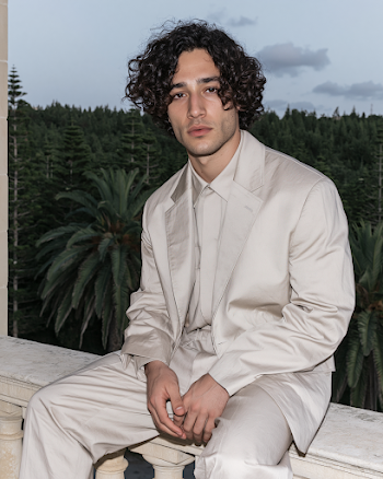 Elegant Man in Light Suit Against Lush Forest Background