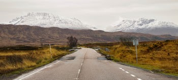 Empty Asphalt Road With Mountain Range in Background
