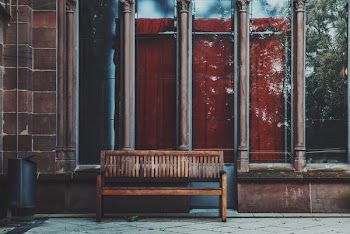 empty brown wooden bench near shop