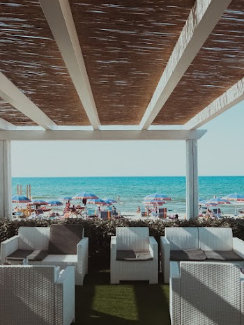 Empty Chairs and Sofas Under White and Brown Shed at Beach