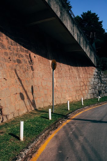 Empty Concrete Road Near Brick Wall