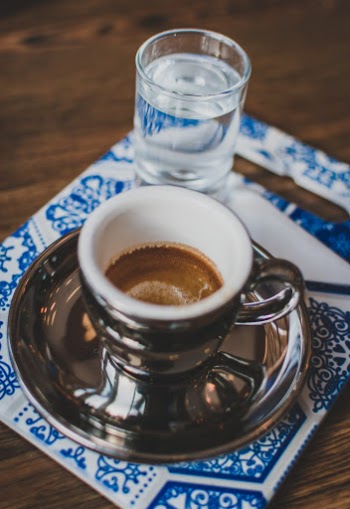 Empty espresso shot with a cool glass of water to wash it down. 
