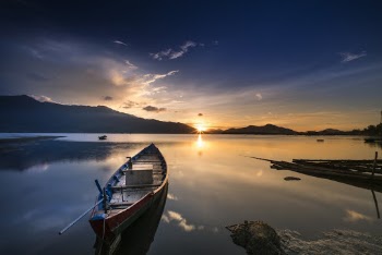 Empty Gray Canoe Boat Near Shore during Golden Hour