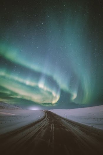 empty road under aurora phenomenon