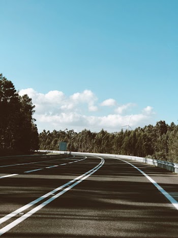 Empty Winding Road Under Blue Sky