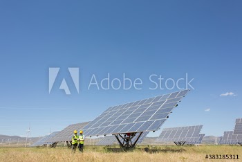 Engineers meeting in sunny rural field with solar panels