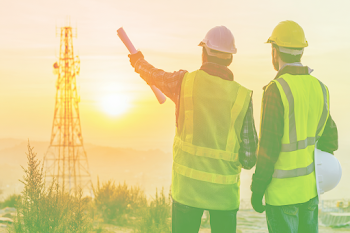 Engineers Overseeing Communication Tower Construction at Sunset