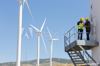 Engineers with digital tablet meeting on wind farm