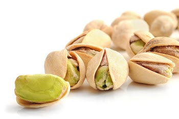 Extreme close-up image of pistachios on white background