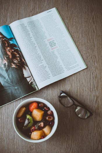 Eyeglasses Beside Bowl of Food and Magazine on Table