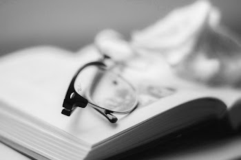 Eyeglasses With Black Frames on top of Book