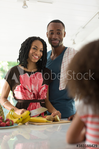 Family cutting fresh fruit in kitchen