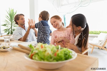 Family eating and playing at patio table