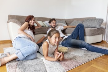 Family laying on the floor while watching tv Free Photo