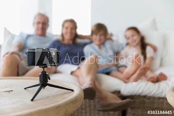 Family posing for automatic photo behind camera on tripod