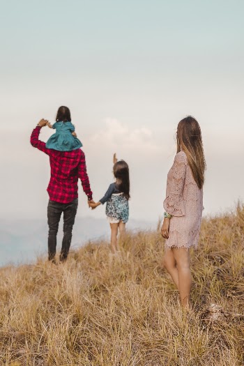 Family Standing on Brown Grass