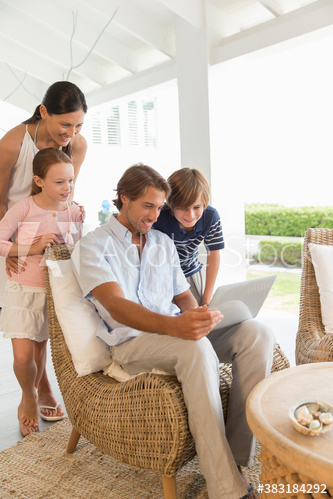 Family using laptop on patio