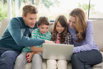 Family using laptop on sofa