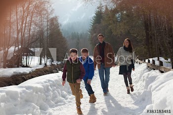 Family walking and running on sunny snowy footpath