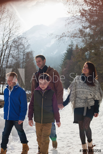 Family walking on sunny snowy footpath