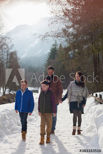 Family walking on sunny snowy footpath