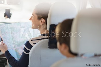 Family with map on road trip in car