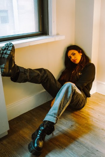 Fashionable young ethnic female millennial sitting on floor near window · Free Stock Photo