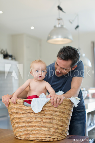 Father and baby son in laundry basket