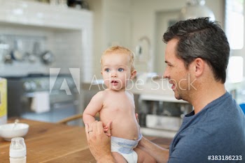 Father and cute baby son at dining table