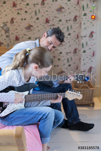 Father and daughter playing electric guitars