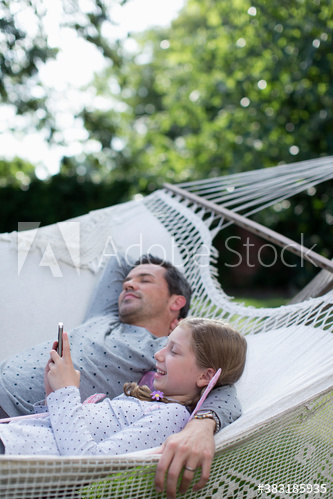 Father and daughter relaxing in hammock