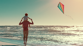 Father and Son Enjoying a Beach Day with a Kite
