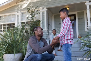 Father and son talking in front of house