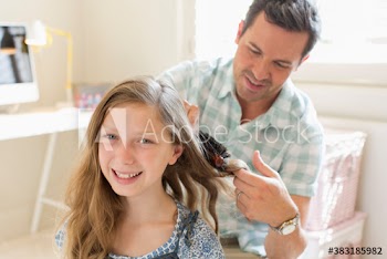 Father brushing hair of daughter