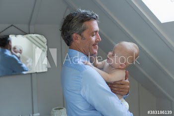 Father holding curious baby son