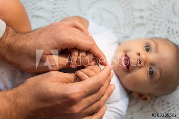 Father holding hands of baby son