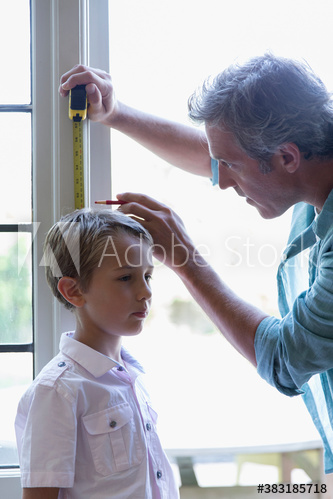 Father measuring height of son