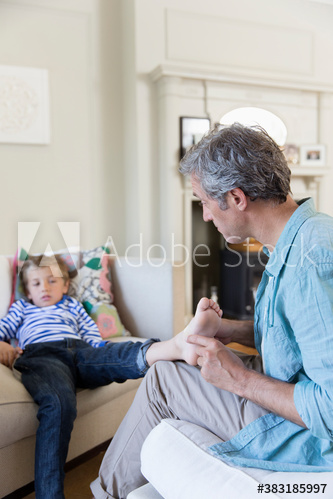 Father tickling foot of son