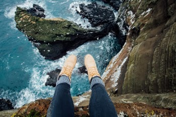 feet hanging over loranger cliffs in iceland