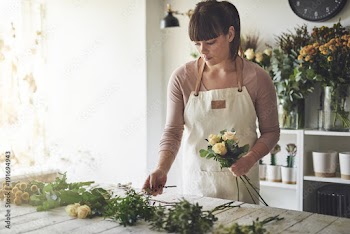 Female florist making a flower arrangement in her shop