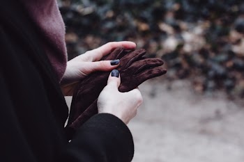 Female hands holding leather gloves