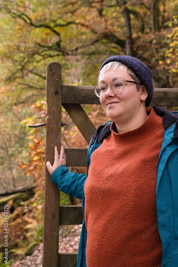 Female hiker walking through gate in forest