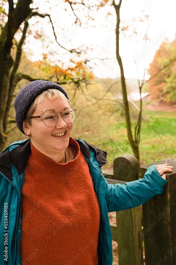 Female hiker walking through gate in forest
