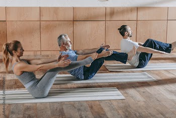 female instructor exercising with mature men at training class