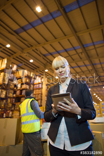 Female manager using digital tablet in distribution warehouse